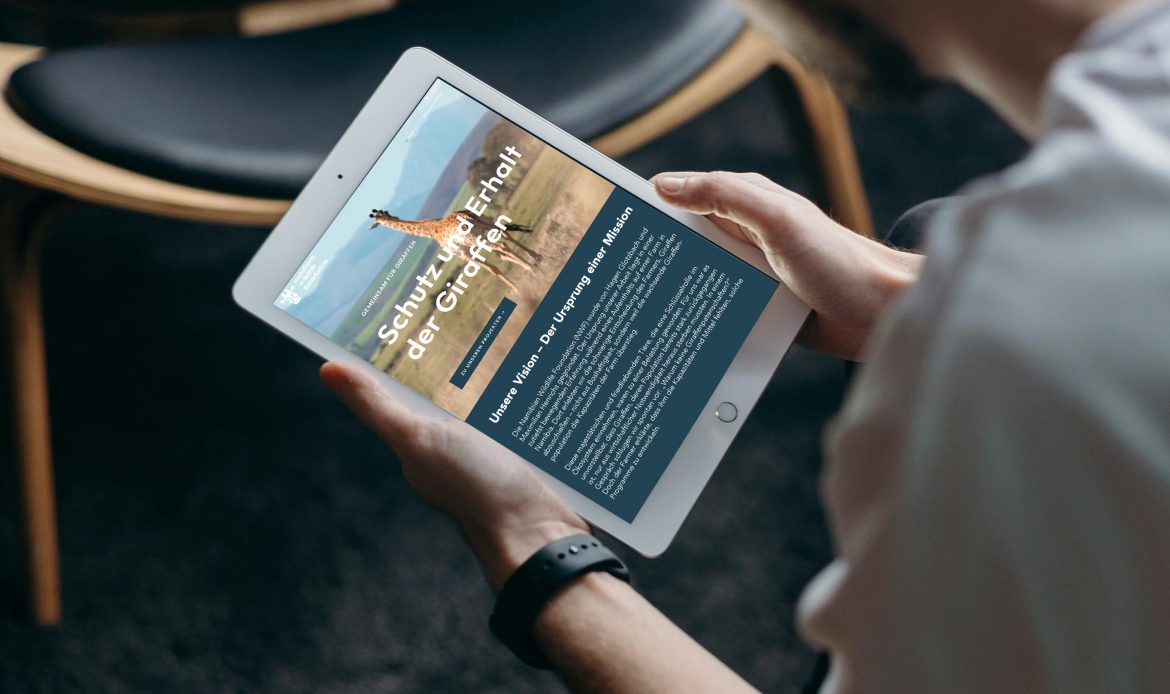 Person liest auf einem Tablet den Newsletter der Namibian Wildlife Foundation über Giraffenschutz