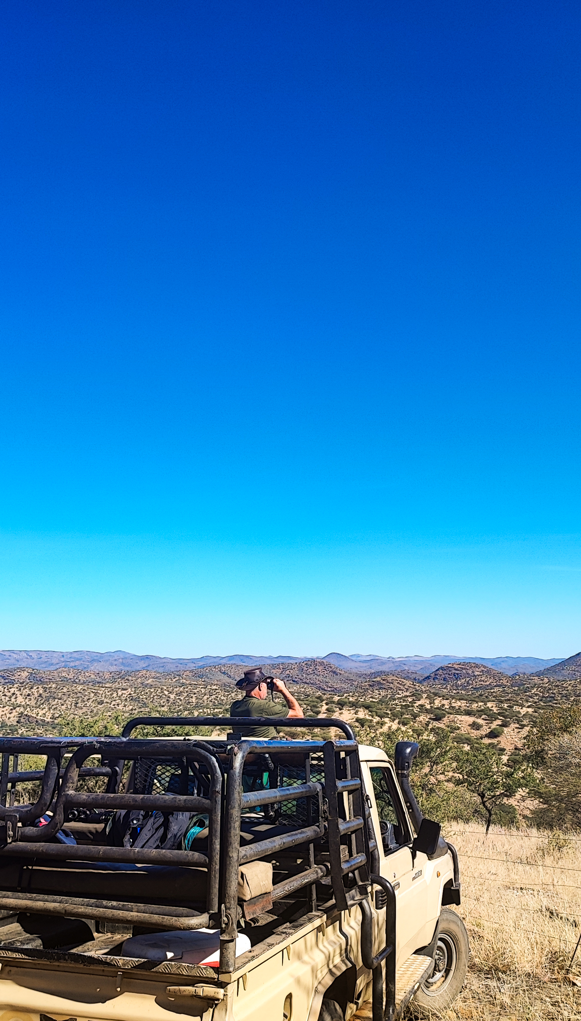 Wildhüter beobachtet vom Safari-Fahrzeug aus die Landschaft im Khomashochland, Namibia