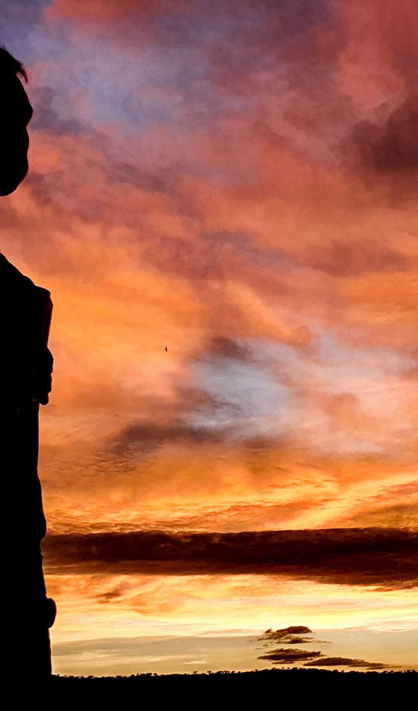 Sonnenuntergang_im_Khomashochland Person in Silhouette vor farbenprächtigem Sonnenuntergang im Khomashochland, Namibia
